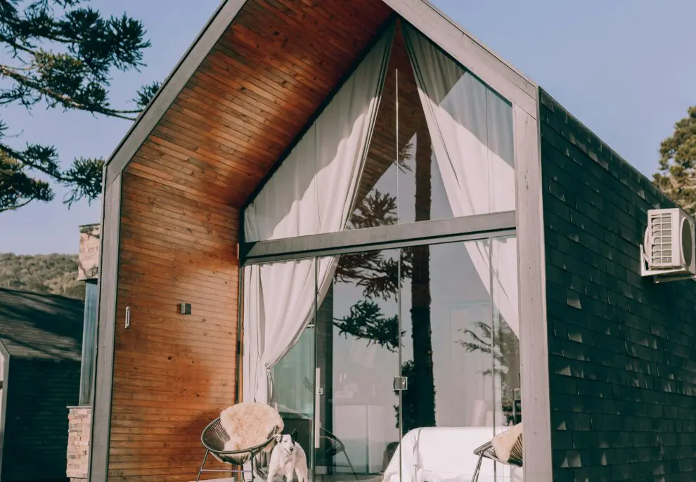 Stylish wooden cabin with glass front set in a serene outdoor environment.